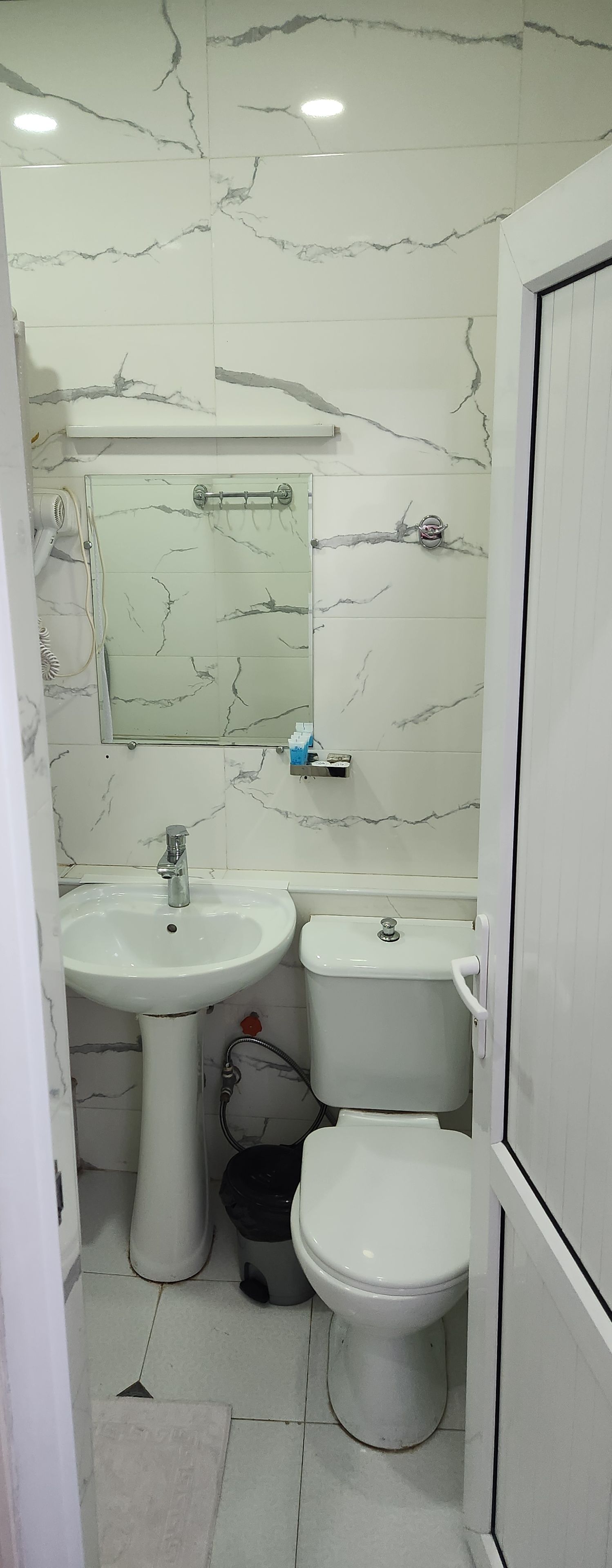 Un baño con lavamanos, inodoro y bidé, todo en blanco.