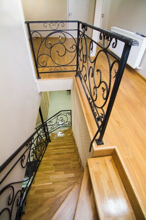 A wooden staircase with ornate black metal railings.
