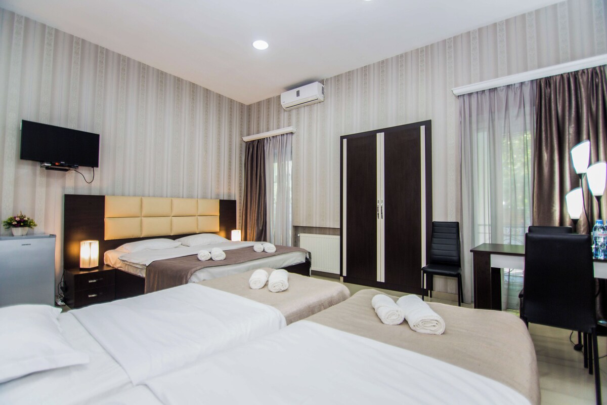 Deluxe Quadruple Room | Peti besi dalam bilik, meja, ruang kerja komputer riba 