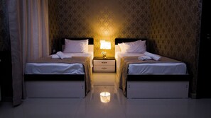 A hotel room with two beds, a nightstand with a lamp, and a mirror. - Old Georgia (Tbilisi)