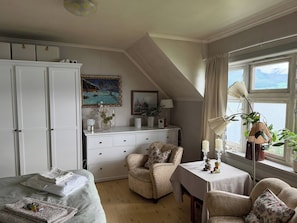 A room with a bed, a desk, a chair, a wardrobe, and a window with a view. - Central 2-bedroom Sea View Apartment (Volda)
