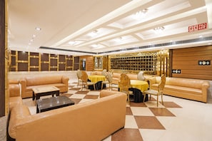 A spacious lobby with leather sofas, round tables, and a checkered floor pattern. - Collection O Sector 5 Ghaziabad (Ghaziabad)