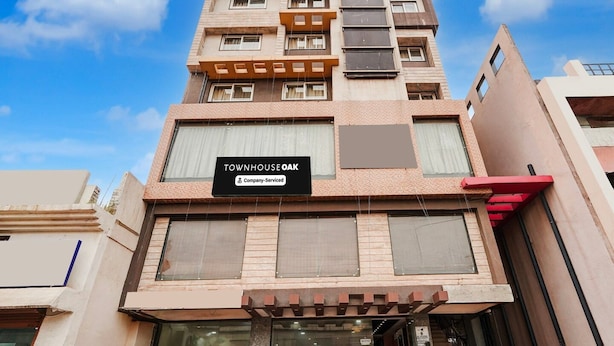 Un edificio de varios pisos con un cartel que dice 'TOWNHOUSE OAK Company Serviced'.