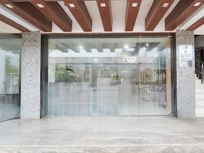 A reception area with a glass door, a reception sign, and a stone pillar with a plaque. - Townhouse Oak Bhilai Railway Junction (Durg)
