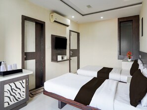 A hotel room with a bed, bedside table, air conditioning unit, and a television. - Townhouse Oak Bhilai Railway Junction (Durg)