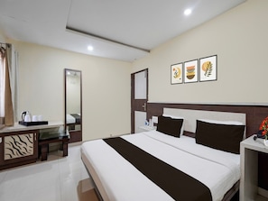 A hotel room with a large bed, a bedside table, a mirror, and a wall with three framed pictures. - Townhouse Oak Bhilai Railway Junction (Durg)