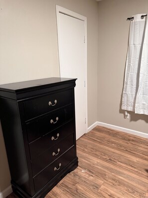 A room with a black dresser, a white door, and a white curtain. - Awesome 3-bedroom house with AC in vibrant Houston (Houston)