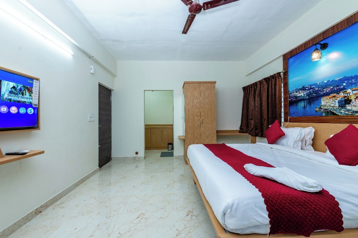 Ein Hotelzimmer mit Bett, Fernseher, Schrank und einem Bild an der Wand.