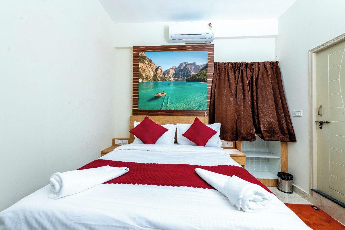 Una habitación de hotel con una cama, un cuadro de un lago, una cortina marrón y un cubo de basura.