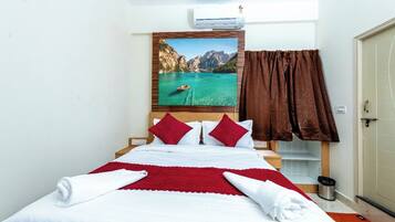 Una habitación de hotel con una cama, un cuadro de un lago, una cortina marrón y un cubo de basura.