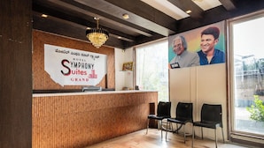 Eine Hotelrezeption mit Holzausstattung, einem Kronleuchter und einem großen Plakat zweier Personen.