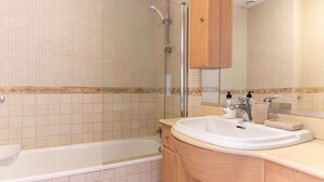 Ein Badezimmer mit einer Badewanne, einem Waschbecken und einer Dusche.