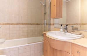 Ein Badezimmer mit einer Badewanne, einem Waschbecken und einer Dusche.