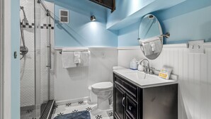 Ein Badezimmer mit Dusche, Toilette, Waschbecken und Spiegel.