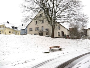 A residential area with a snow-covered hill, a bench, and a road. - Holiday Home in Morbach With Swimming Pool (Morbach)