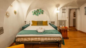 A bedroom with a bed, a nightstand, a lamp, and a radiator. - In the Heart of Florence · 4 Min to Duomo & David (FIRENZE)