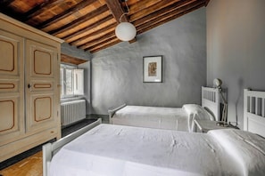 A bedroom with two beds, a radiator, a wardrobe, and a ceiling fan. - Villa with natural spring amid Lucca vineyards (Lucca)