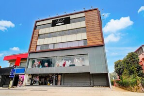A multi-story building with a storefront featuring mannequins displaying clothing.