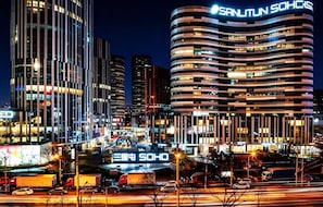 A modern urban skyline with illuminated buildings, including a prominent curved structure with 'SANLITUN SOHO' signage. - Siye Serviced Residence (Beijing)
