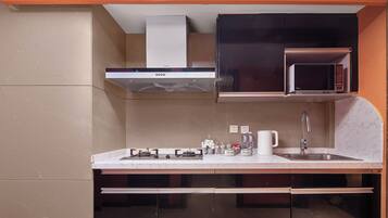 A modern kitchen with a built-in microwave, gas stove, and stainless steel sink.