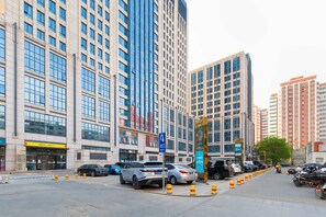 A city street with tall buildings, parked cars, and a pedestrian crossing. - Siye Serviced Residence (Beijing)