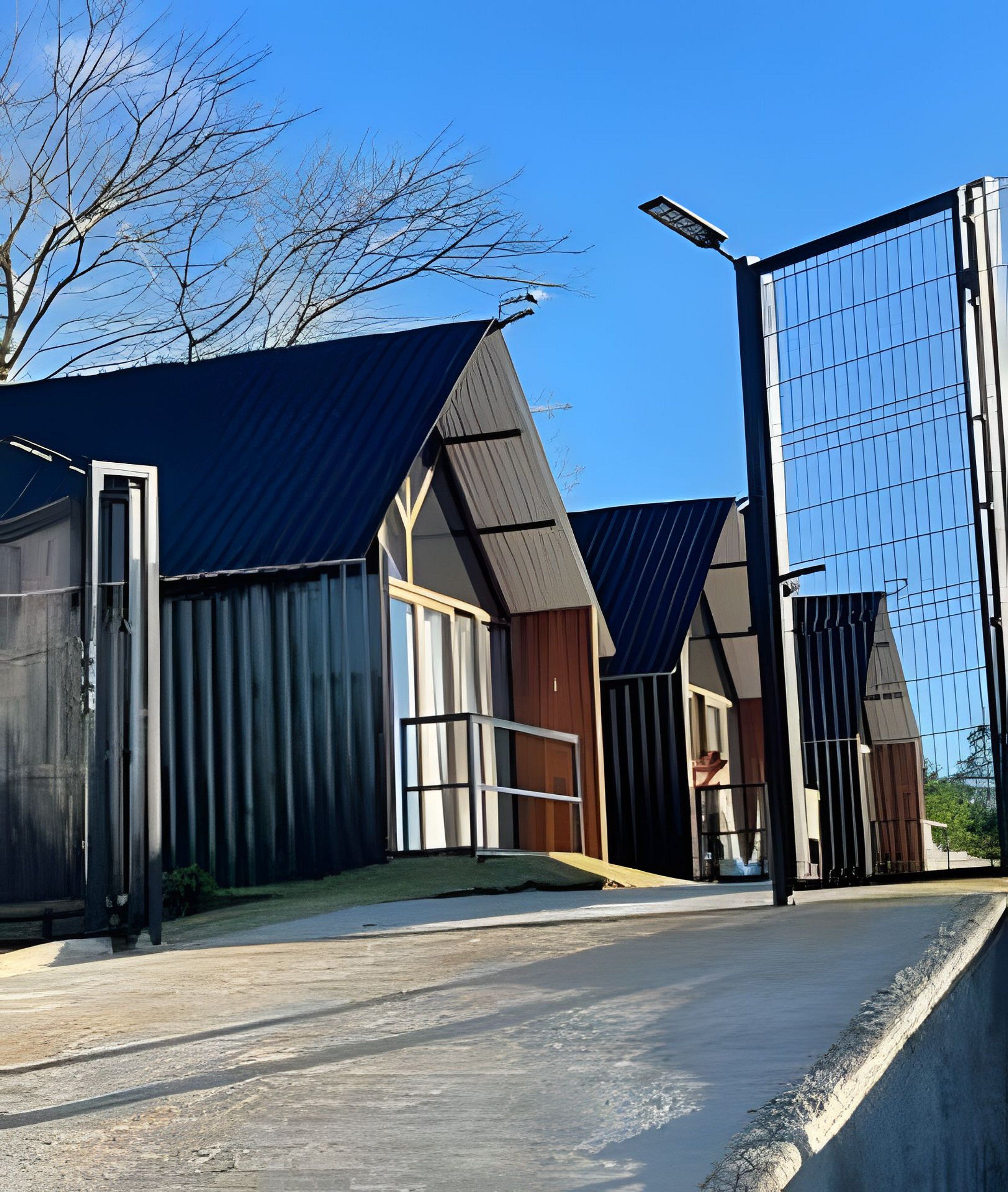Een modern gebouw met een metalen gevel en een helderblauwe lucht.