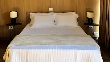 Ett hotellrum med en säng, två sängbord och lampor.