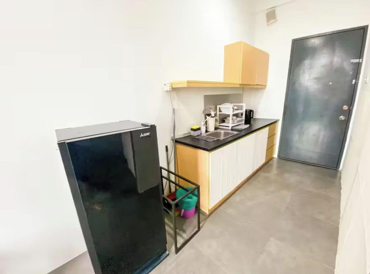 A compact kitchen with a refrigerator, a sink, and a cabinet.
