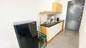 A compact kitchen with a refrigerator, a sink, and a cabinet.