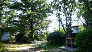 Ein Garten mit Barbereich, Picknicktisch und kleiner Gartenhütte.