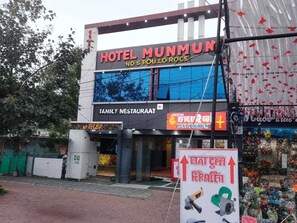 A hotel with a sign for a family restaurant and a signboard with various items.