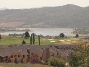 A residential area with houses, a golf course, and a body of water in the background. - Ski Condo and Summer Resort (Eden)