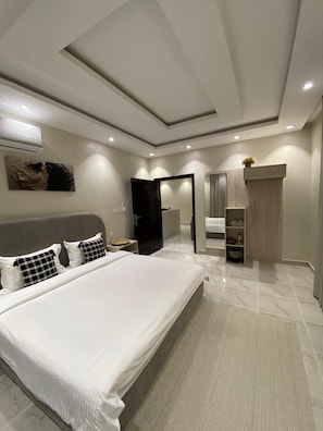 Una camera da letto moderna con un letto grande, un cabina armadio e un bagno con doccia e WC.