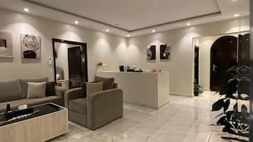 A modern living room with a sofa, coffee table, and a reception desk.