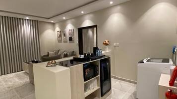 Una cocina moderna con una isla central, electrodomésticos integrados y un extintor.