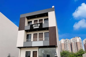 Un moderno edificio de hotel con un letrero llamativo, múltiples ventanas y un balcón.