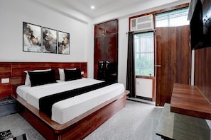 Un dormitorio moderno con una cama grande, un armario de madera y un televisor.