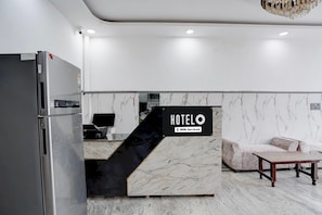 Una mesa de recepción de hotel con un cartel que indica que es administrado por OYO.
