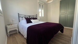 Un dormitorio con cama, mesita de noche y armario.