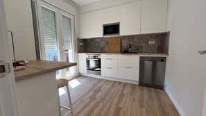 Een moderne keuken met een inbouwoven, magnetron en vaatwasser.