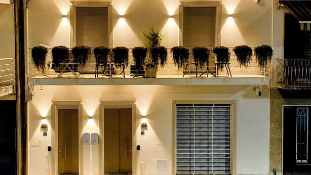 Un edificio a due piani con un balcone, porte doppie e un basculante per garage.