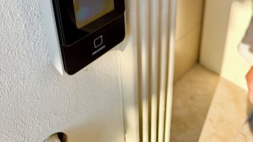 Cerradura digital instalada en una pared blanca con textura, probablemente para un hotel o apartamento.