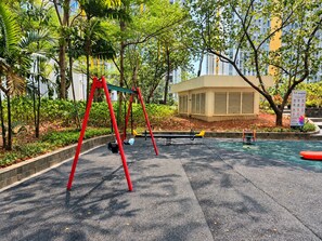 Une aire de jeux avec des balançoires et une petite piscine.