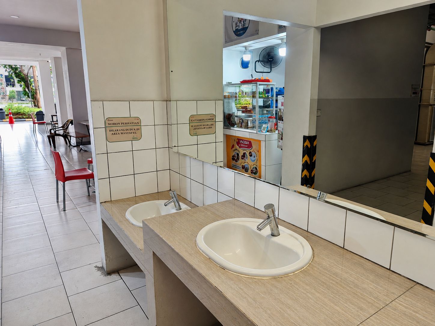 Un baño limpio con dos lavamanos, un espejo y un cubo de basura.