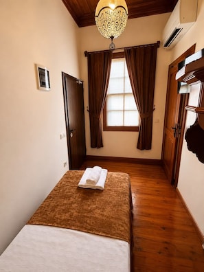 A hotel room with a bed, a window with curtains, a wooden floor, and a ceiling light fixture. - Sais Hotel Kaleiçi (Antalya)