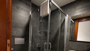 A modern bathroom with a glass-enclosed shower, a white toilet, and a beige sink. - Sais Hotel Kaleiçi (Antalya)