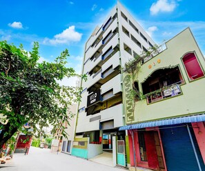 A multi-story building with a sign indicating it is a hotel. - Deluxe With Balcony (Tirupati)