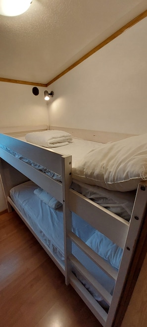 A bunk bed with a headboard, a small window, and a light fixture above it. - 🌊 Fully equipped mobile home for 4 people – SIBLU Mimizan Plage (Mimizan)