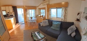 A compact living space with a sofa, a dining table, and a kitchen area. - 🌊 Fully equipped mobile home for 4 people – SIBLU Mimizan Plage   (Mimizan)