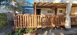 A wooden deck with a covered area, a door, and a sign indicating 'PLAGE'. - 🌊 Fully equipped mobile home for 4 people – SIBLU Mimizan Plage (Mimizan)